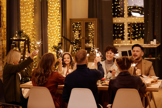 Eine Familie in festlicher Kleidung feiert gemeinsam am weihnachtlich gedeckten Tisch.