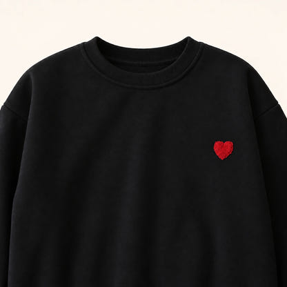 Partnerlook Vater Sohn Pullover – Detail des kleinen roten Herzens auf dem schwarzen Sweatshirt