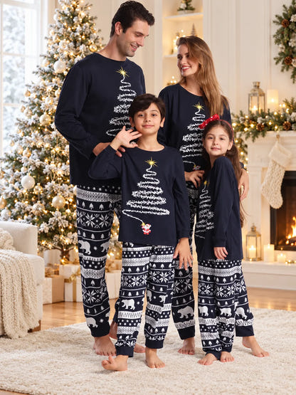 Weihnachtspyjama Blau – Familie im dunkelblauen Pyjama mit weißem Weihnachtsbaum und gemusterter Hose im Weihnachtszimmer